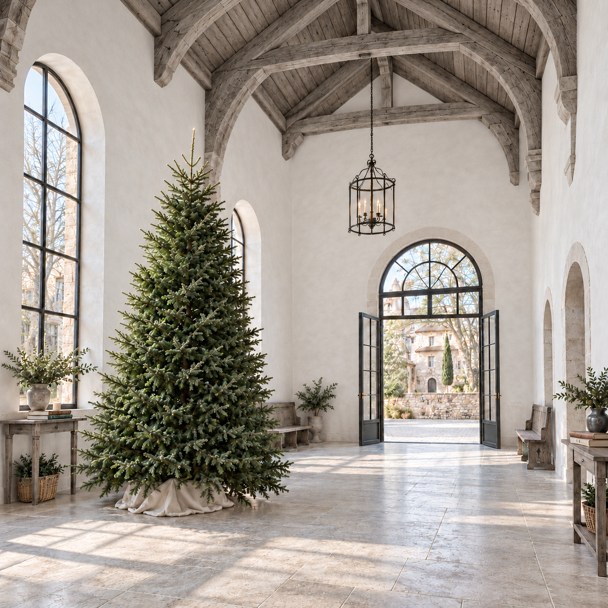 A full Fraser fir beneath timber beams beside open arched doors overlooking the courtyard.